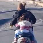 Mujer conduce moto con cerveza y sin casco su hija